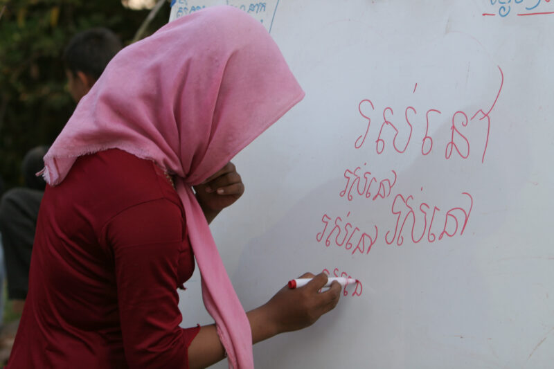 Learning to Read — Women in a Muslim village in Rural Cambodia gather to learn how to read, in a ADRA program that has come to their village — Cambodia, Wome...