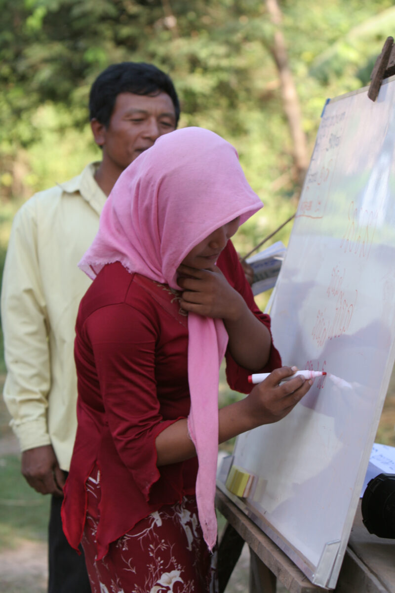 Learning to Read — Women in a Muslim village in Rural Cambodia gather to learn how to read, in a ADRA program that has come to their village — Cambodia, Wome...