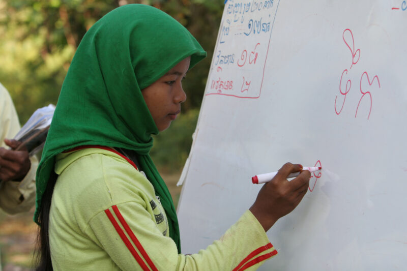 Learning to Read — Women in a Muslim village in Rural Cambodia gather to learn how to read, in a ADRA program that has come to their village — Cambodia, Wome...