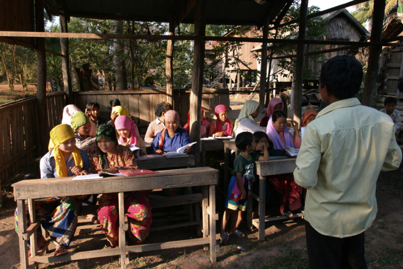Learning to Read — Women in a Muslim village in Rural Cambodia gather to learn how to read, in a ADRA program that has come to their village — Cambodia, Wome...