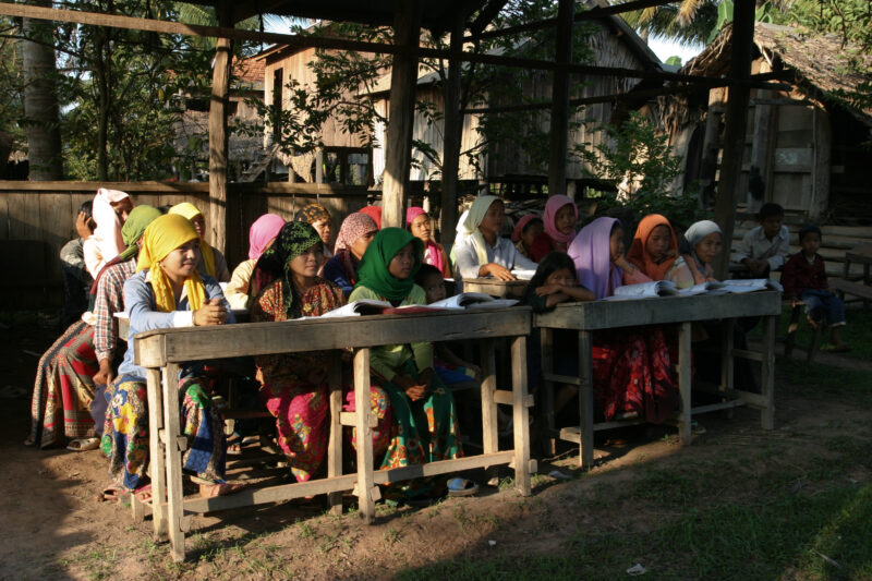 Learning to Read — Women in a Muslim village in Rural Cambodia gather to learn how to read, in a ADRA program that has come to their village — Cambodia, Wome...