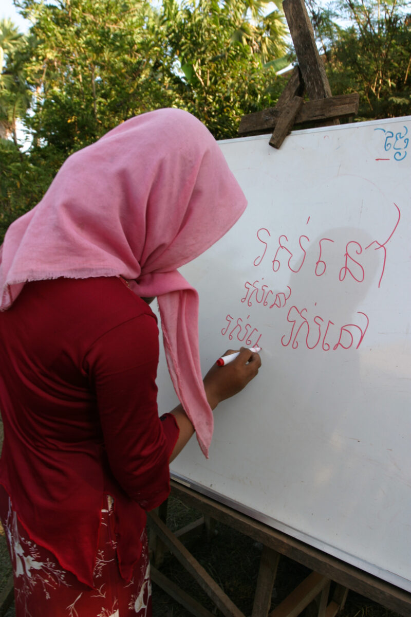 Learning to Read — Women in a Muslim village in Rural Cambodia gather to learn how to read, in a ADRA program that has come to their village — Cambodia, Wome...