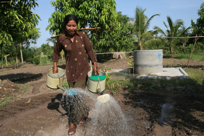 Watering Garden in Cambodia — Stock image of irrigating fields by hand with watering cans, during the dry season in Cambodia. — Cambodia, agriculture, market...