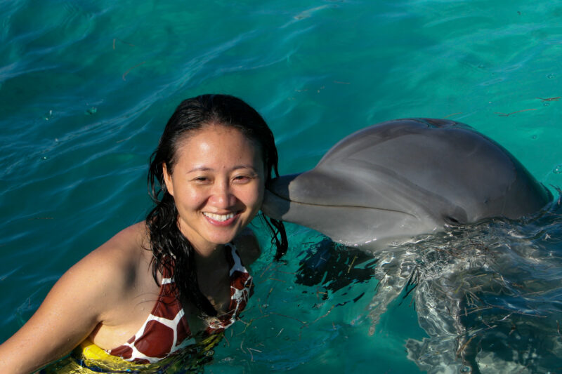 Kissed by a Dolphin — Asian woman enjoys a swiming with dolphins program in the Dominican Republic — Dominican Republic, Woman, women, Asian, Swimming