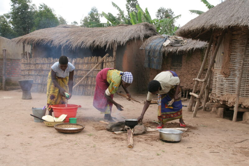 Food Preporation in Malawi — Women cook emeergency food rations over an open fire by their home in a village in Malawi — Malawi, Africa, food, preporation, c...