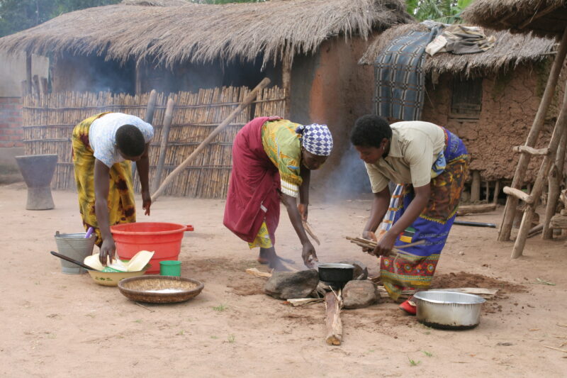 Food Preporation in Malawi — Women cook emeergency food rations over an open fire by their home in a village in Malawi — Malawi, Africa, food, preporation, c...