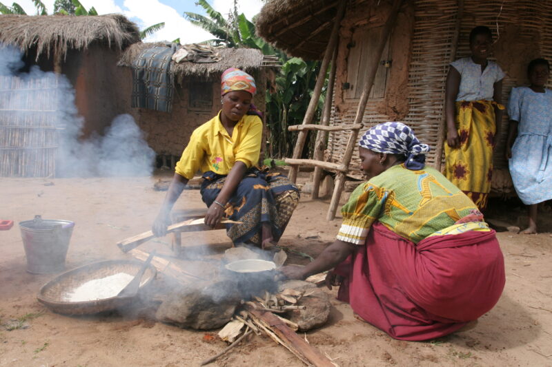 Food Preporation in Malawi — Women cook emeergency food rations over an open fire by their home in a village in Malawi — Malawi, Africa, food, preporation, c...
