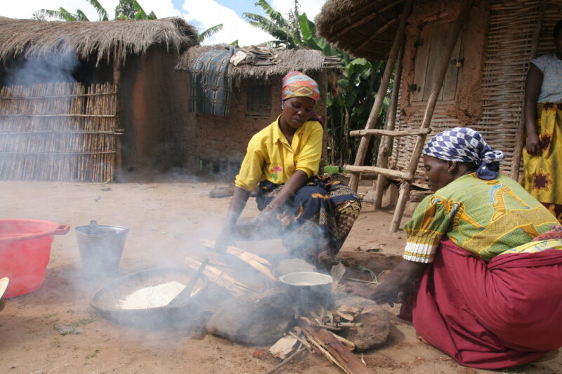 Food Preporation in Malawi — Women cook emeergency food rations over an open fire by their home in a village in Malawi — Malawi, Africa, food, preporation, c...
