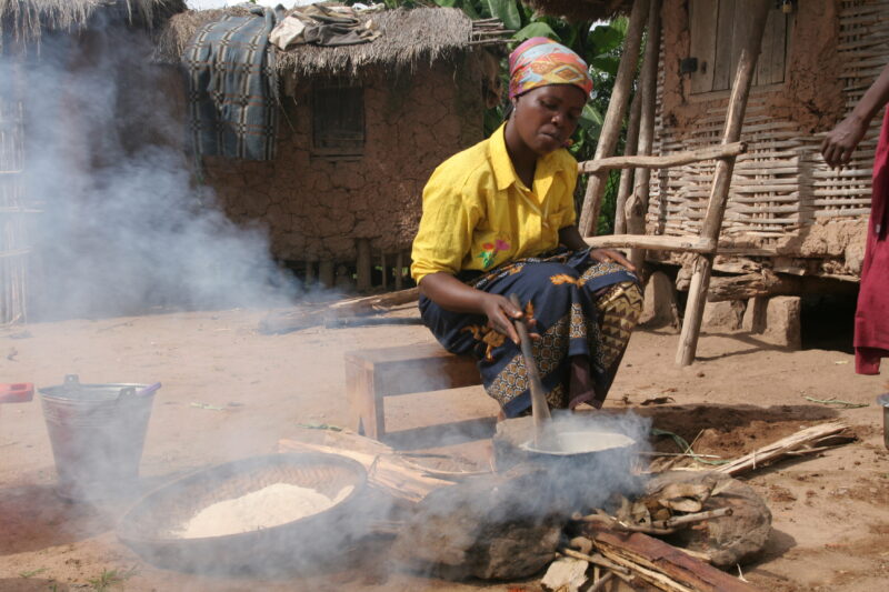 Food Preporation in Malawi — Women cook emeergency food rations over an open fire by their home in a village in Malawi — Malawi, Africa, food, preporation, c...