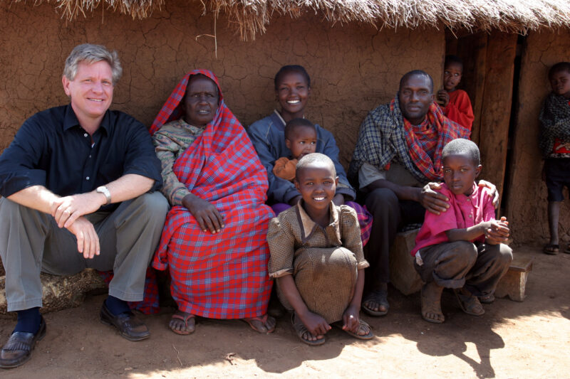 Family pose in front of their house with ADRA Director Max Church — Tanzania, Africa, Hanang