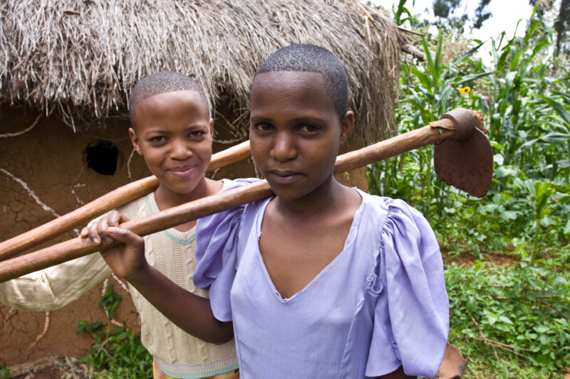 Girls in their Hoes — Girls pose for the camera with their hoes, after working in the family garden, in Hanag district, Tanzania — ADRA, Africa, Development,...
