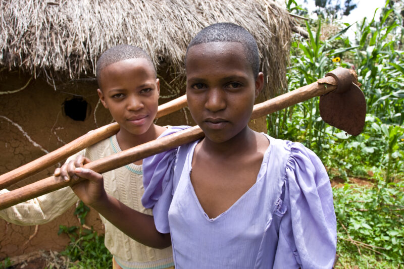 Girls in their Hoes — Girls pose for the camera with their hoes, after working in the family garden, in Hanag district, Tanzania — ADRA, Africa, Development,...