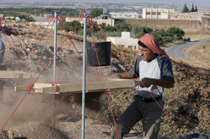 Sifting for Treasure — Students and Local workers, hired for the dig session, sift through the dirt that comes out of the squares, to catch small items like ...