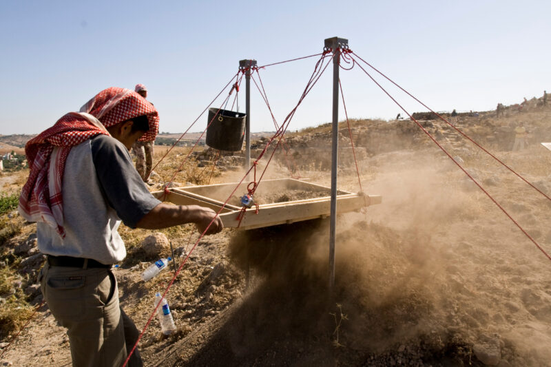 Sifting for Treasure — Students and Local workers, hired for the dig session, sift through the dirt that comes out of the squares, to catch small items like ...