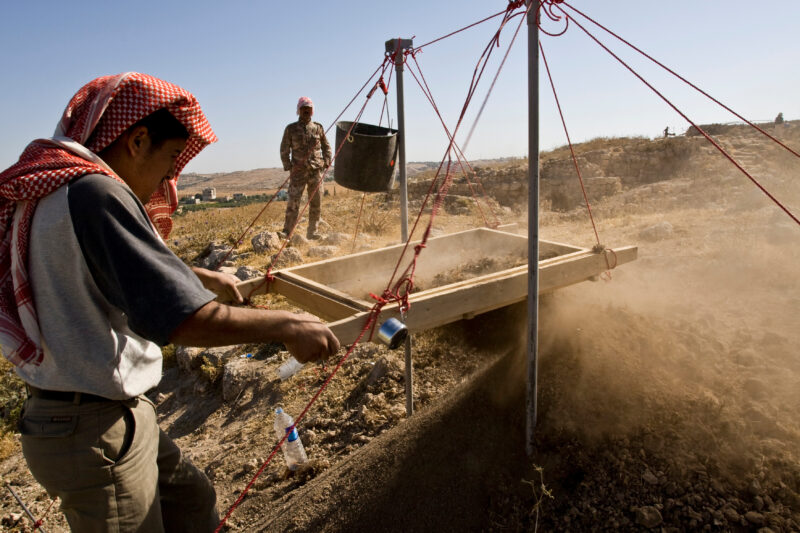 Sifting for Treasure — Students and Local workers, hired for the dig session, sift through the dirt that comes out of the squares, to catch small items like ...