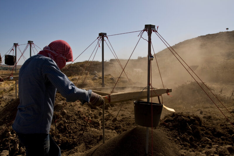 Sifting for Treasure — Students and Local workers, hired for the dig session, sift through the dirt that comes out of the squares, to catch small items like ...