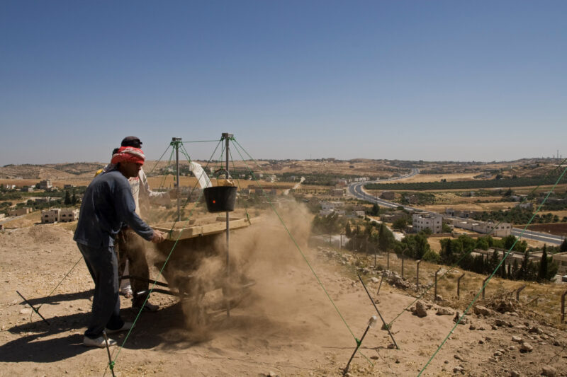 Sifting for Treasure — Students and Local workers, hired for the dig session, sift through the dirt that comes out of the squares, to catch small items like ...