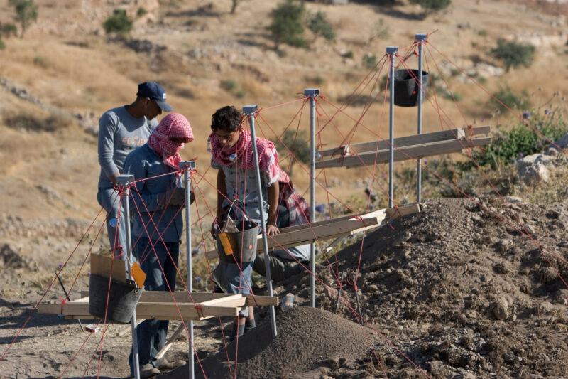 Sifting for Treasure — Students and Local workers, hired for the dig session, sift through the dirt that comes out of the squares, to catch small items like ...
