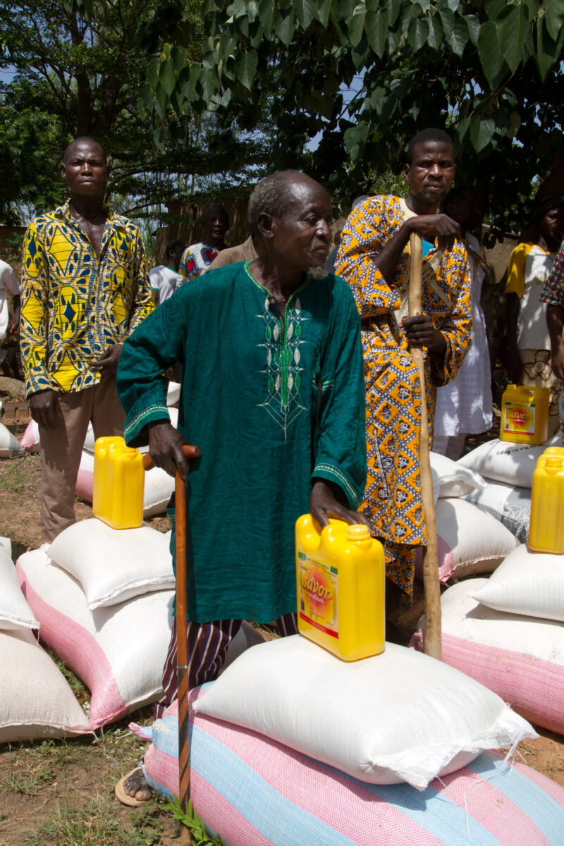 Food Distribution — Villagers stand by the food they are receiving to help them over a bad drought in Burkina Faso, Africa. — Africa, West Africa, Burkina Fa...