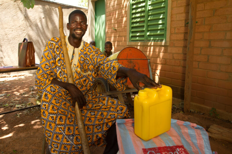 Receiving Food — Man with disability poses with food that she has received from an Emergency food Distribution program sponsored by the Canadian Foodgrains B...