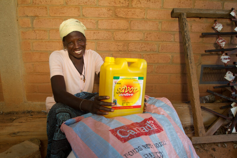 Receiving Food — Woman with disability poses with food that she has received from an Emergency food Distribution program sponsored by the Canadian Foodgrains...