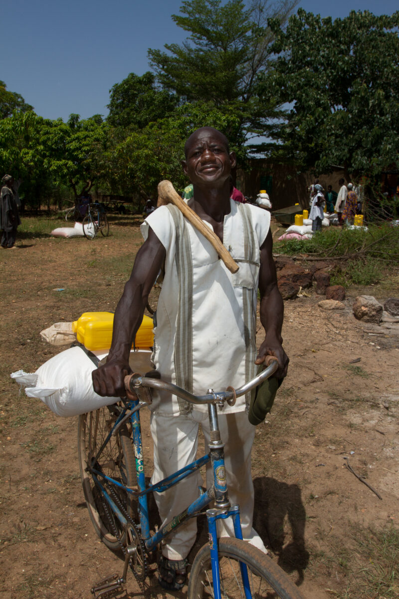 Food Distribution — Taking home food on the back of a bicycle. — Africa, West Africa, Burkina Faso, poor, poverty
