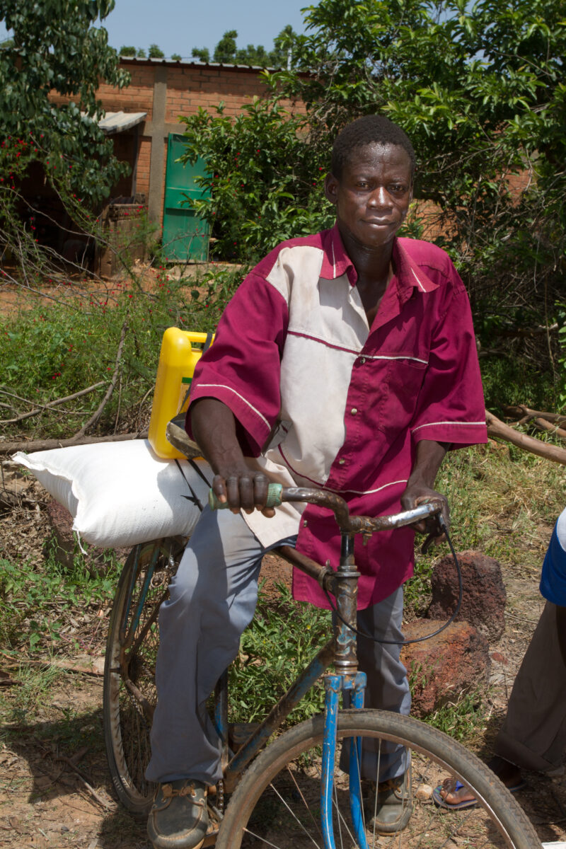 Food Distribution — Taking home food on the back of a bicycle. — Africa, West Africa, Burkina Faso, poor, poverty
