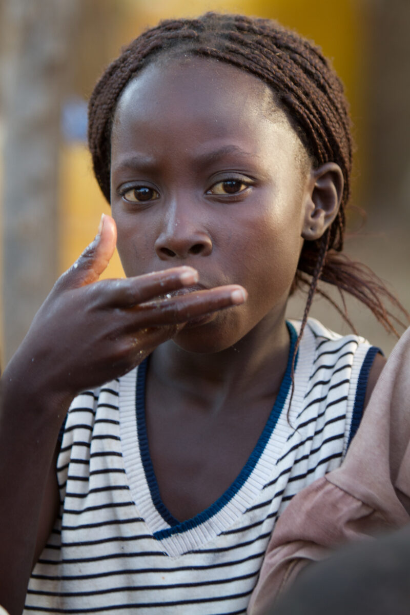 Girl Eats — Girl in Burkina Faso eats food that her family has received from the Canadian Foodgrains Bank, during a drought in her part of Africa. — Africa, ...