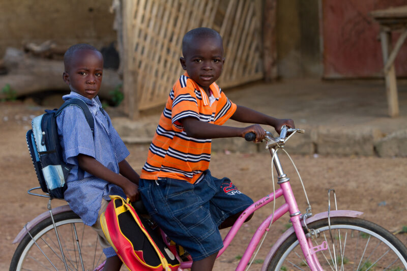 Going to School — Boys ride bike to school in Burkina Faso — Africa, West Africa, Burkina Faso, poor, poverty
