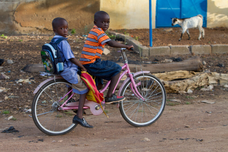 Going to School — Boys ride bike to school in Burkina Faso — Africa, West Africa, Burkina Faso, poor, poverty