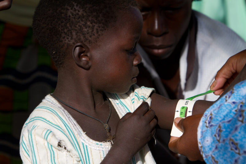 Checking for Malnourishment — Health workers check babies for signs of malnourishment by measuring their arms, at a remote village in Burkina Faso, Africa th...
