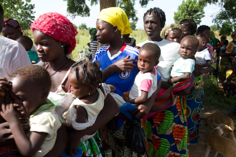Mothers Wait with Babies — Mothers hold their babies as they wait in line for growth monitoring, malnutrition checks and immunizations at an outdoor mobile c...