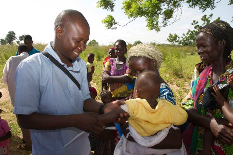 Checking for Malnourishment — Health workers check babies for signs of malnourishment by measuring their arms, at a remote village in Burkina Faso, Africa th...