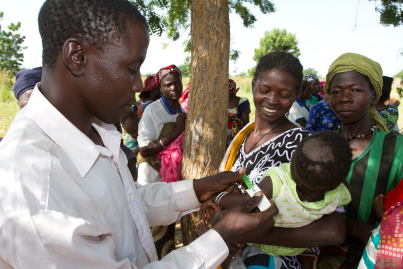Checking for Malnourishment — Health workers check babies for signs of malnourishment by measuring their arms, at a remote village in Burkina Faso, Africa th...