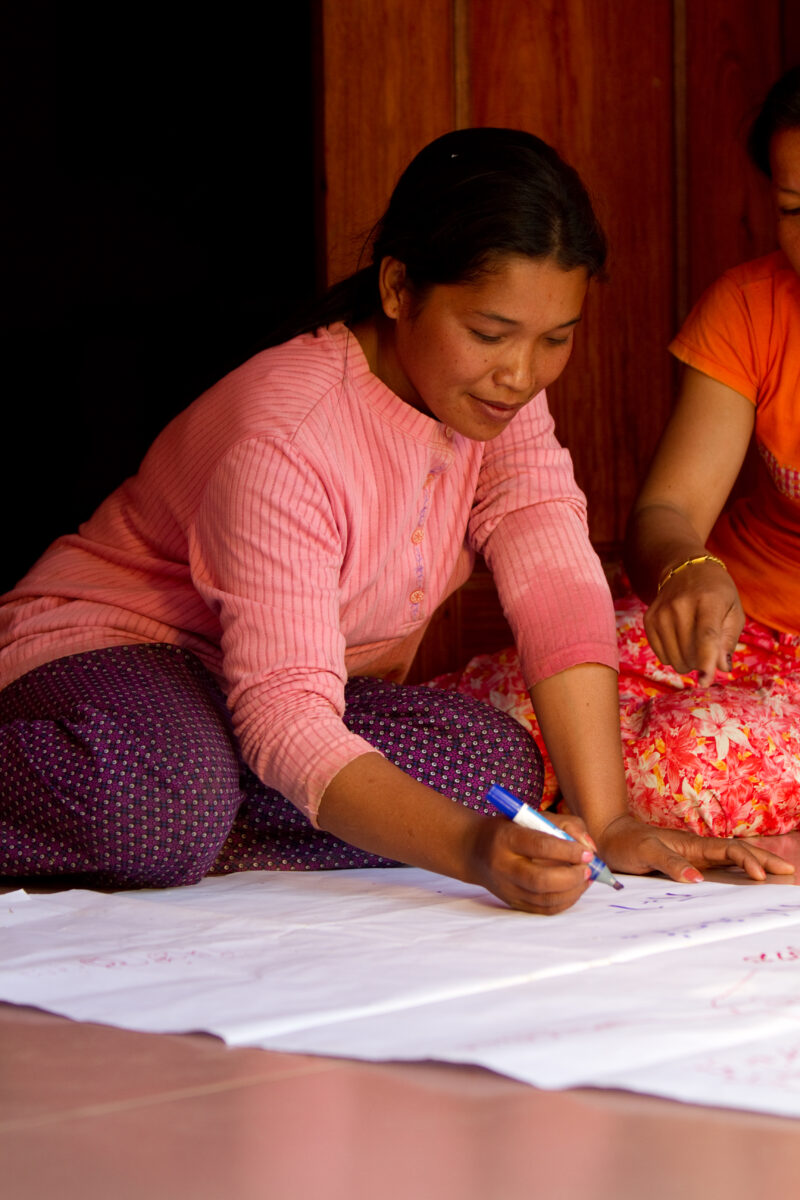 Learning to Read and Write — Stock Images of Cambodia: Woman in literacy program demonstrates her new writing skills — ADRA, Cambodia, Reflect Southeast Asia...