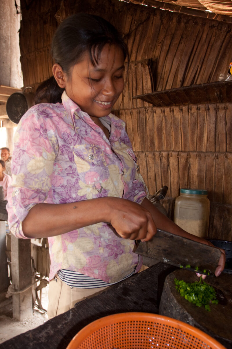 Chopping Onions in Cambodia — Stock image of young girl in Cambodia chopping onions. — Cambodia, ADRA, faces, children, girls