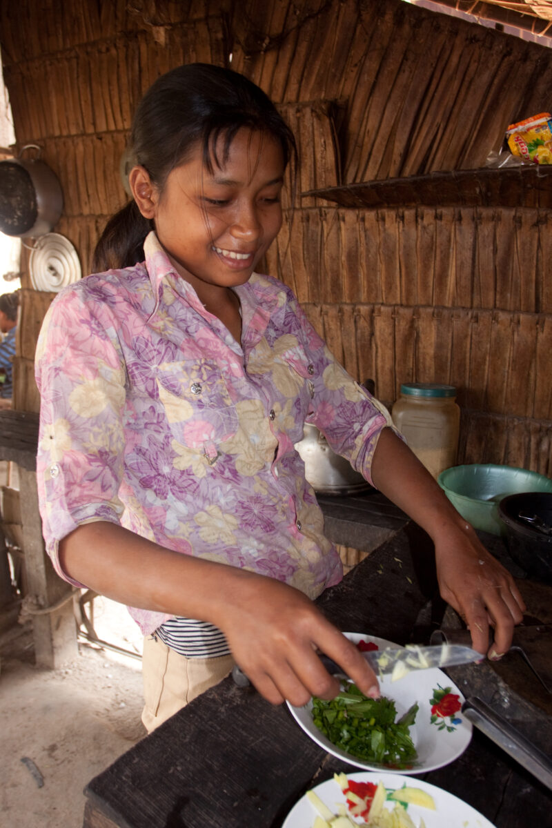 Cooking in Cambodia — Stock image of young girl in Cambodia helping her mother cook. — Cambodia, ADRA, faces, children, girls