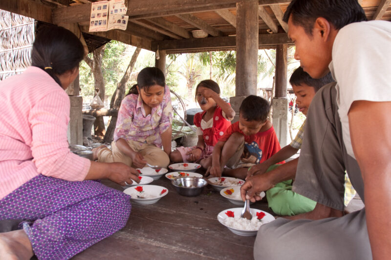 Eating Meal in Cambodia — Stock Image of Cambodia: Family eats a meal of rice and fish, in the shade under their stilted home in Rural Cambodia — Southeast A...