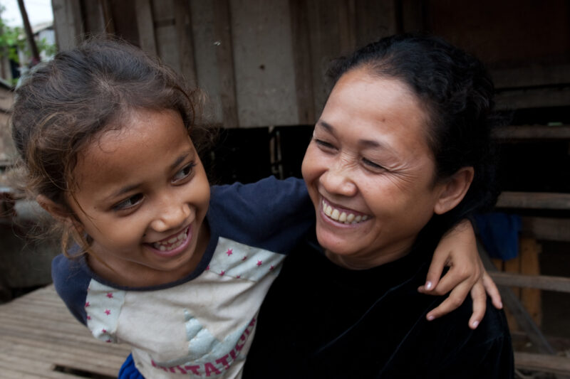 Mother and Daughter in Cambodia — Stock image of young girl in Cambodia hanging on to her mother in front of the doorway of her home in Phnom Penh. — Cambodi...