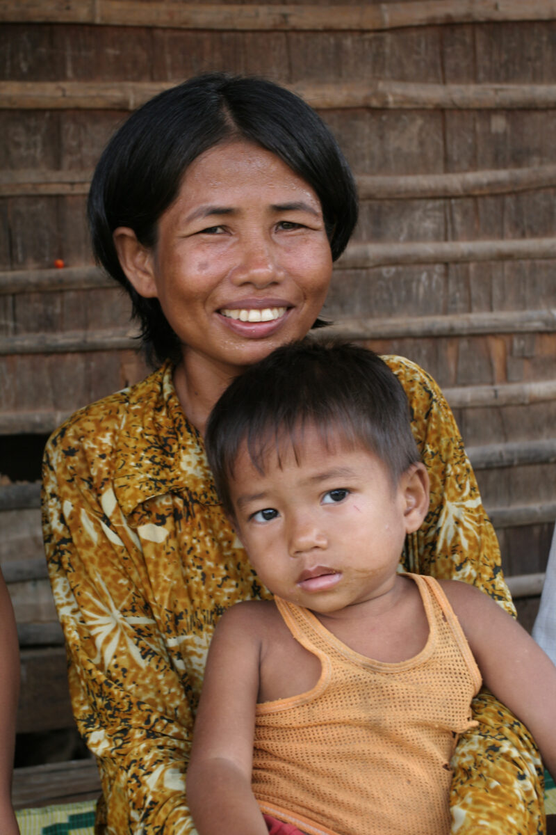 Mother and son in Cambodia — Woman holds her son in front of the simple home in rural Cambodia. — Cambodia, boy, boys, woman, child