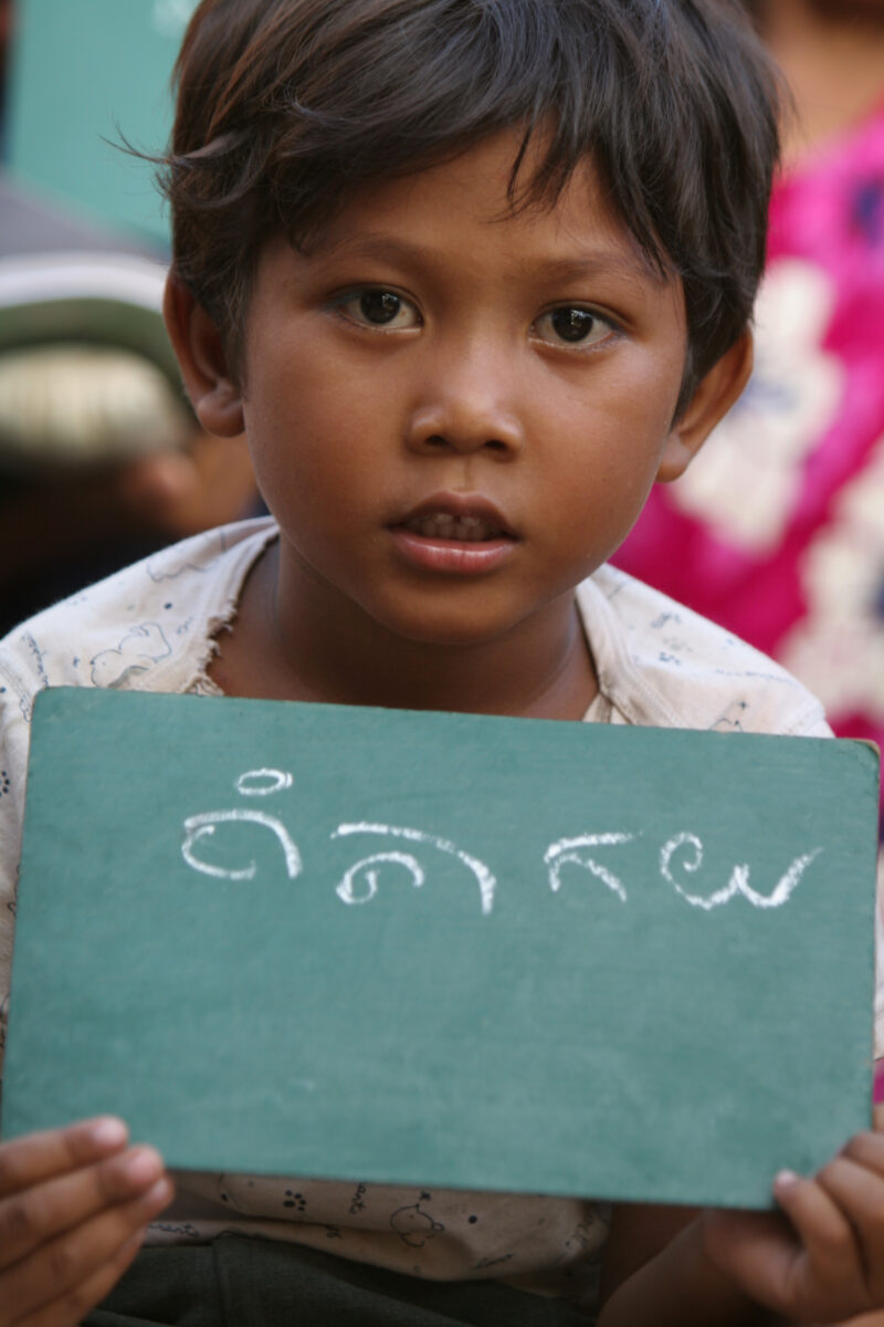 Learning to Write — Young girl displays her ability to write in the Khmer language of Cambodia — Cambodia, faces, child, children, education