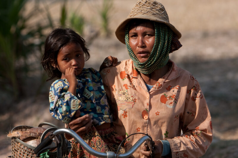 Mother and Daughter in Cambodia — Stock Image of a woman holding her daughter and her bicycle in rural Cambodia — Cambodia, woman, women, mother, gril
