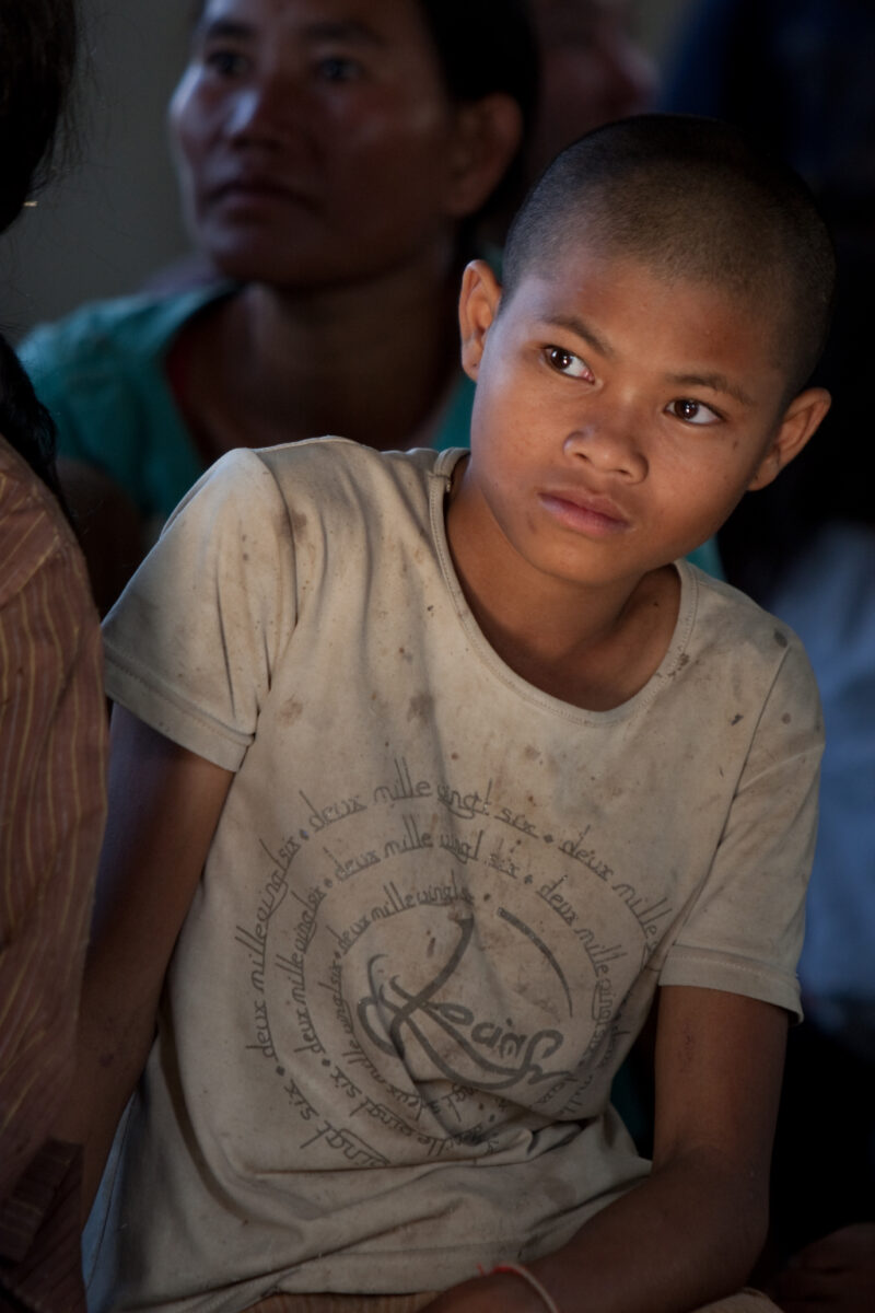 Boy in Cambodia — Boy listens to presentation at Village meeting in Cambodia — Cambodia, boy, boys, faces, child