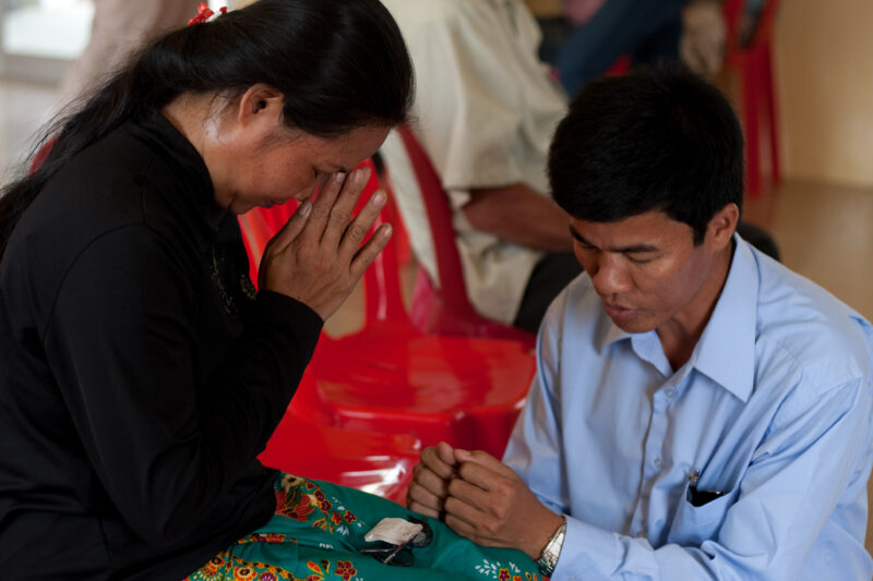 Praying in Cambodia — Couple pray together at a church meeting in Cambodia — Cambodia, Christian, prayer, praying, church