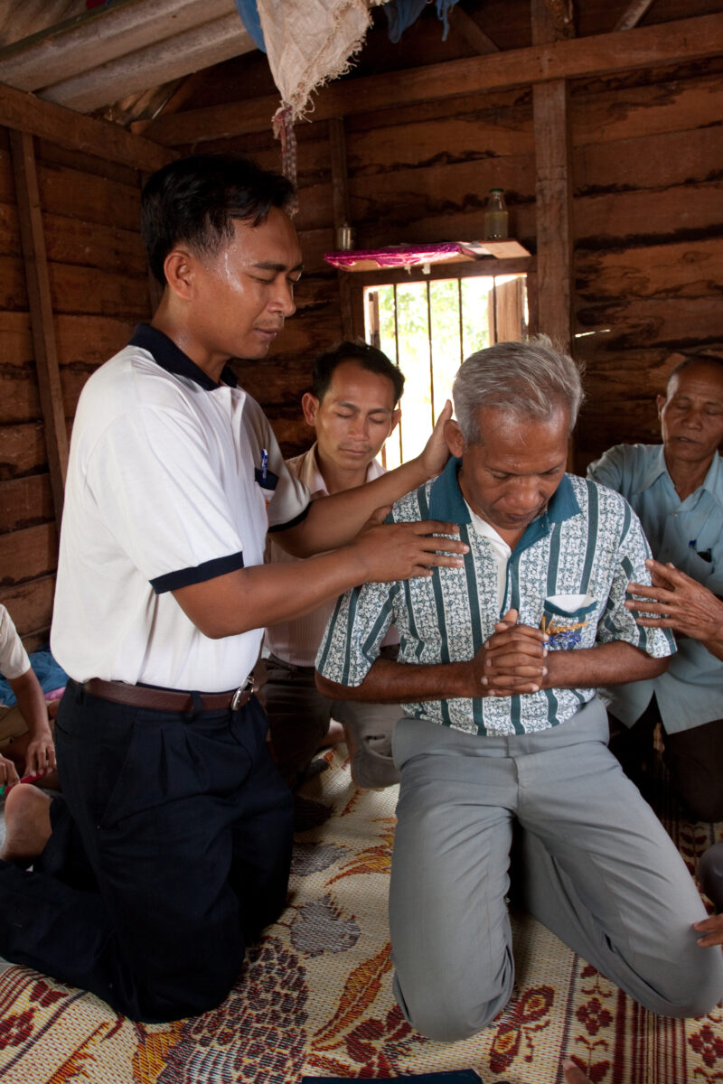 Prayer for Healing — Christians gather around a man to pray for his healing. — Cambodia, Christian, prayer, healing, praying