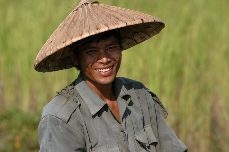 Farmer in His Field in Cambodia — Man smiles as he looks up from his work in his field in rural Cambodia — Cambodia, people, faces, men, Khmer