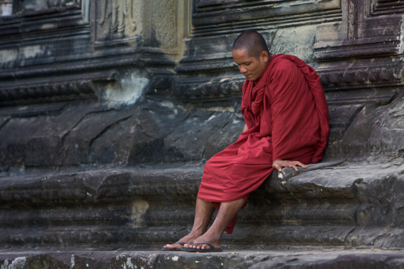 Monk on the Steps of Angkor Wat — Buddhist Monk sits on the steps of the Temple ruins at Angkor Wat, in Siem Reap, Cambodia — Angkor Wat, Cambodia, Siem Reap...