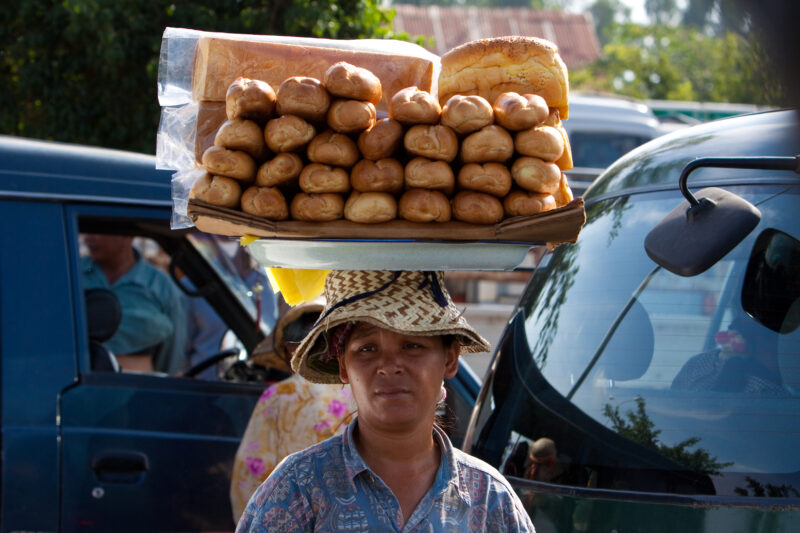 Selling baked Goods in Cambodia — Stock Image of a woman selling baked Goods on the Street — Cambodia, woman, women, bread, baked goods