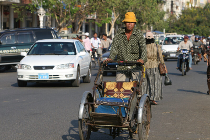 Cyclo Driver in Cambodia — Stock image of cyclo driver working the streets of Phnom Penh, Cambodia: looking for customer — Cambodia, street, streets, traffic...