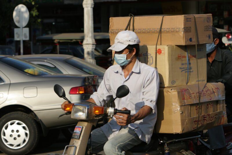 Deliveryman in Cambodia — Man delivers products to customers using his moterbike. — Cambodia, street, streets, traffic, motorcycle